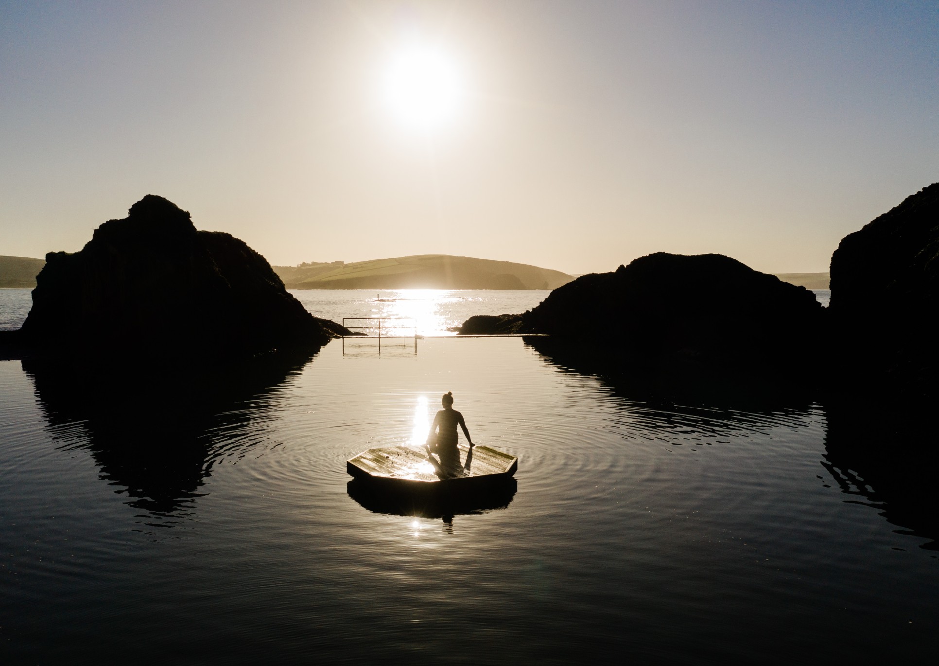 A woman having a sunrise dip at the mermaid pool at Burgh Island