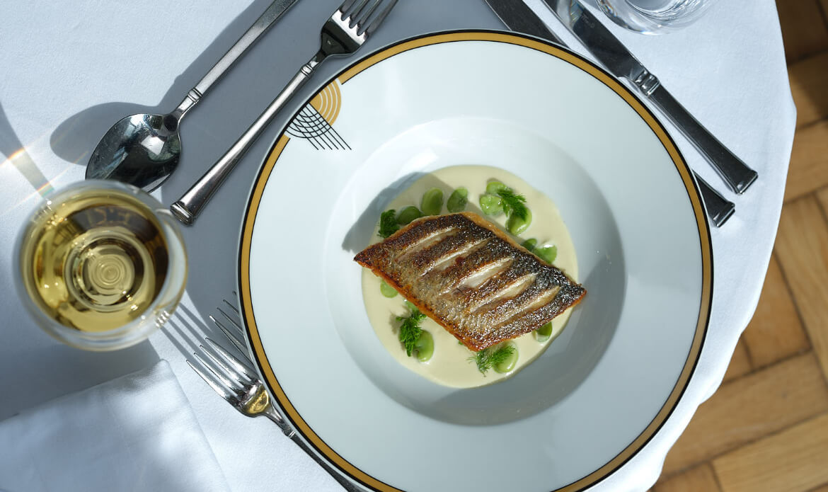 Fish served in a bowl on a laid table at The Grand Ballroom Restaurant at Burgh Island