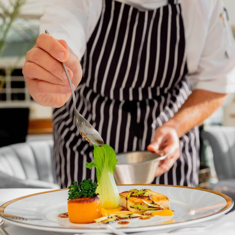 Chef plating Food at The Grand Ballroom Restaurant at Burgh Island