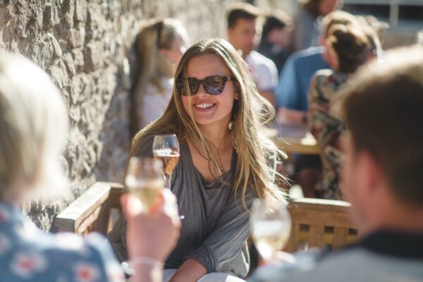 Woman Enjoying a Glass of Sharpham Wine on a Sunny Day